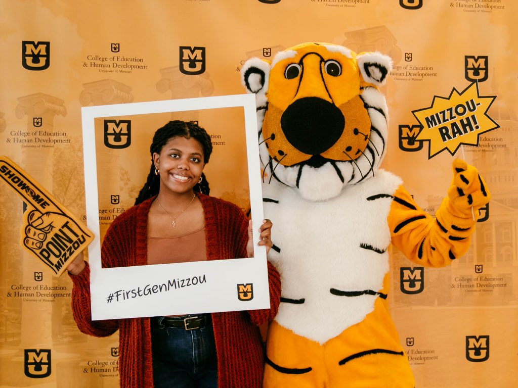 first-generation student celebration in Townsend Lobby,student posing with #firstgenmizzou polaroid frame next to Truman