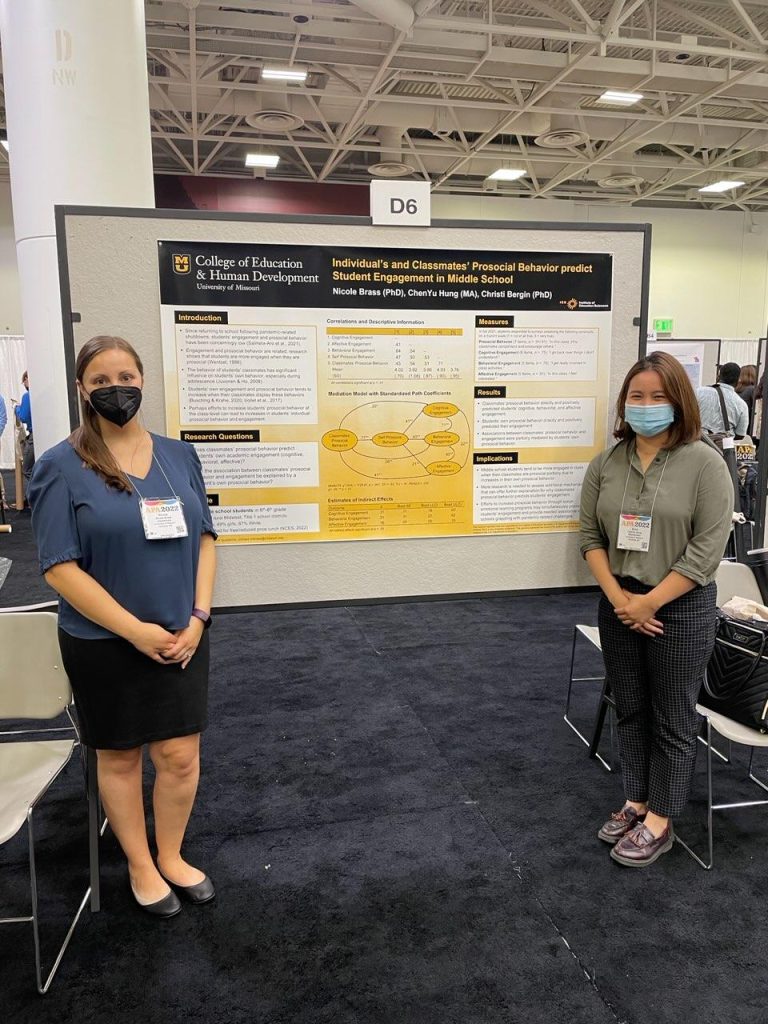 Two people in front of a research poster