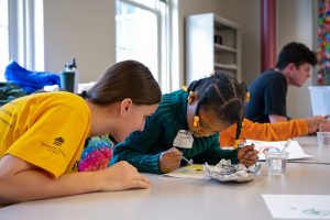 A Mizzou student works with an elementary student on a science lesson