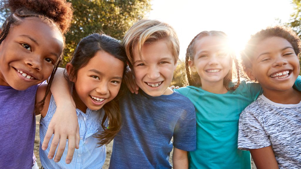 Portrait Of Multi-Cultural Children Hanging Out With Friends In Countryside Together