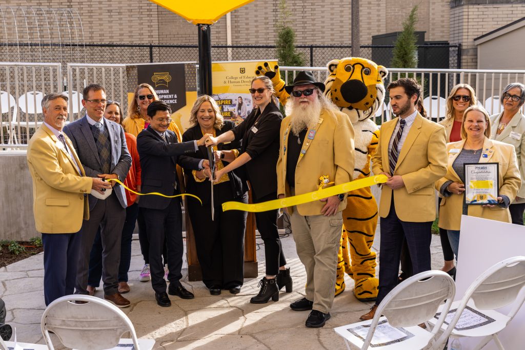 Members of the administration and community cutting a ribbon.