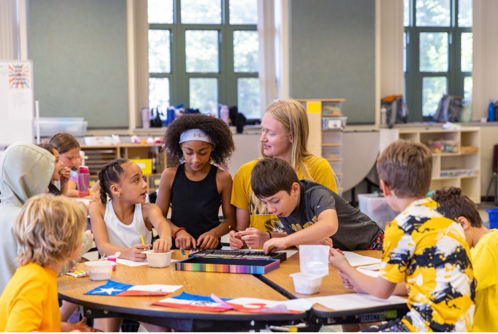 a group of students and a site leader at a table