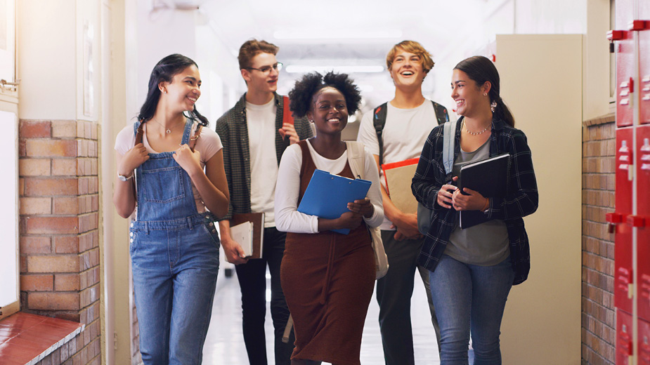 Group of older students walking through a school hallway