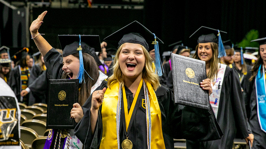 Female student cheering with diploma