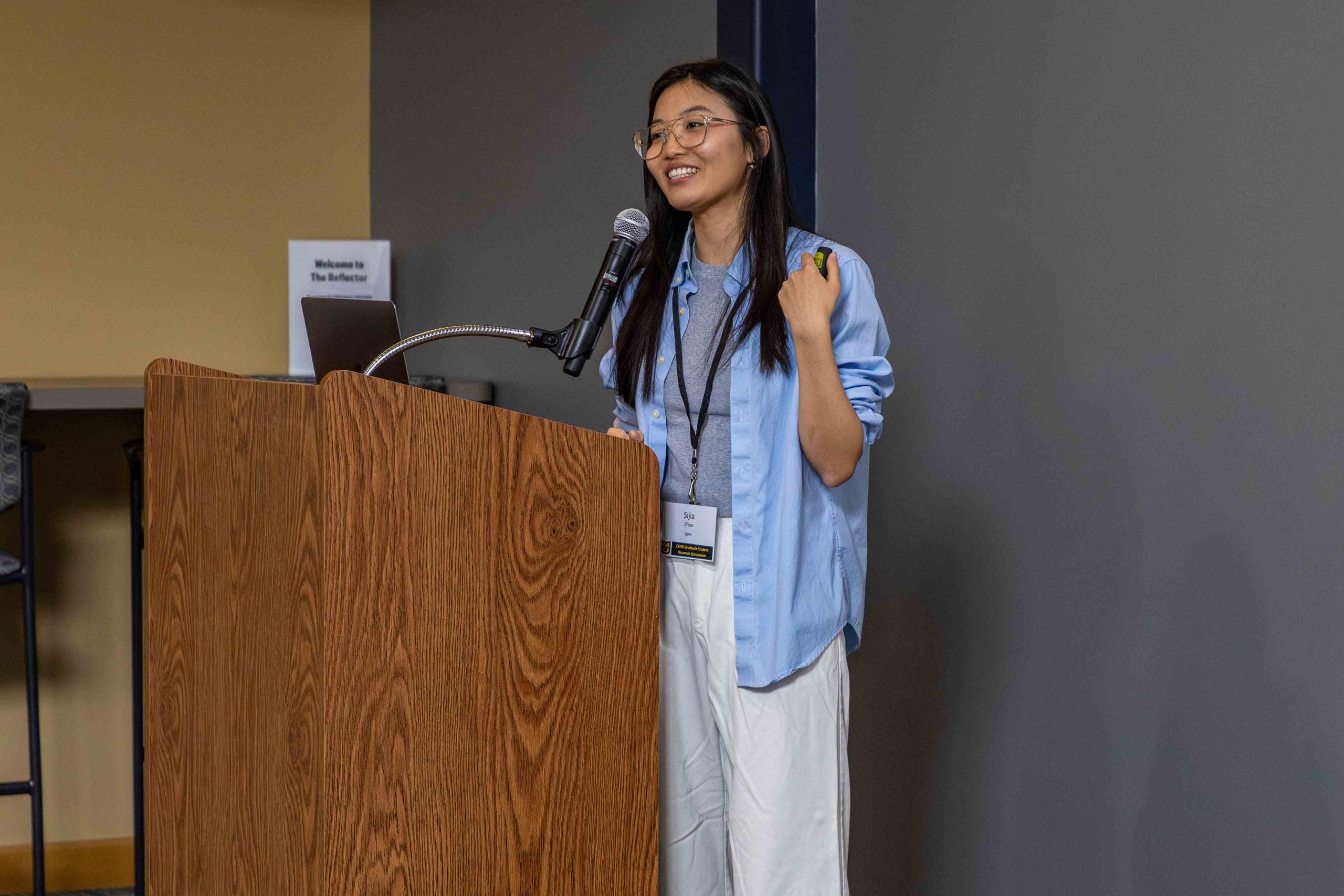 student, Sija Zhao, standing behind a podium