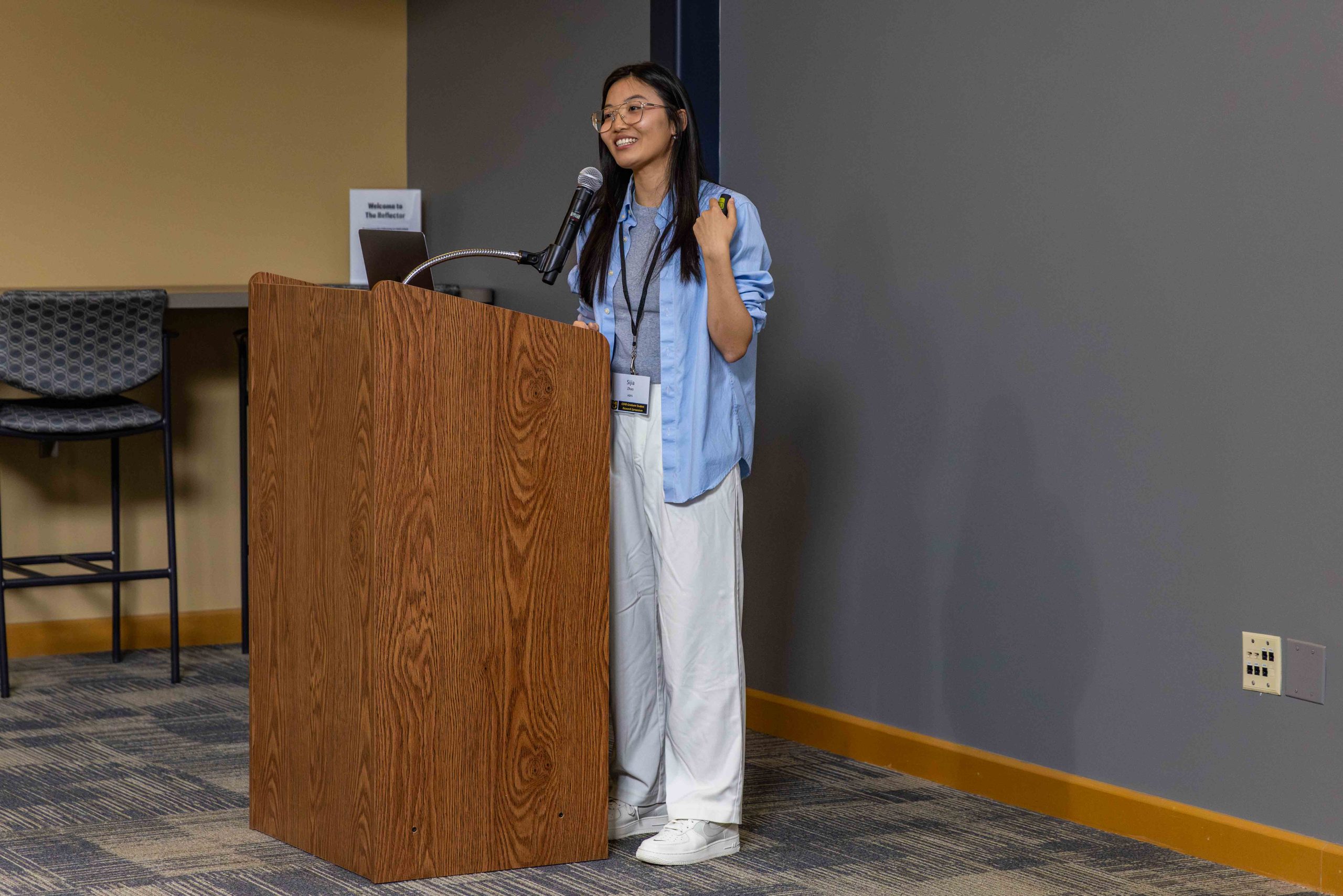 student, Sija Zhao, standing behind a podium