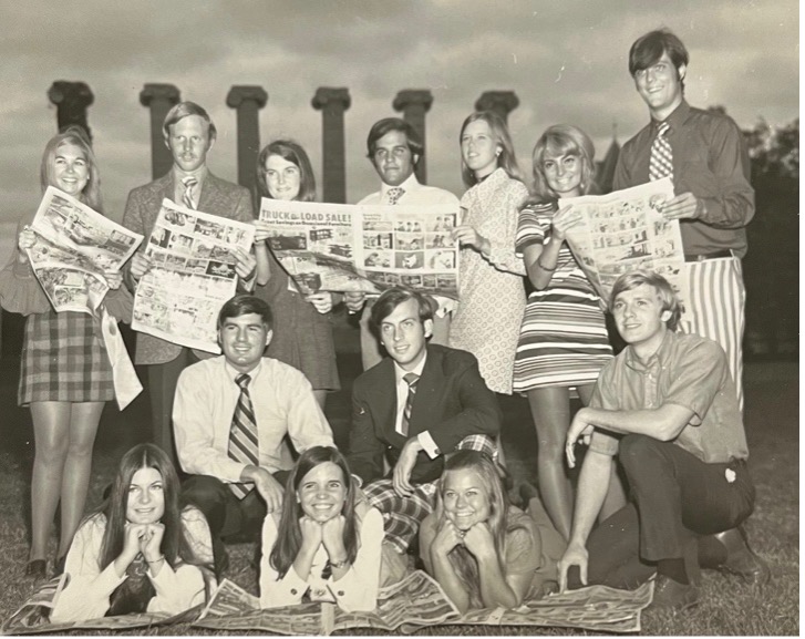 Cindy Roszell (center, ground) and Steve Roszell (kneeling behind her in white shirt and tie) during Homecoming Steering Committee activities, 1970.