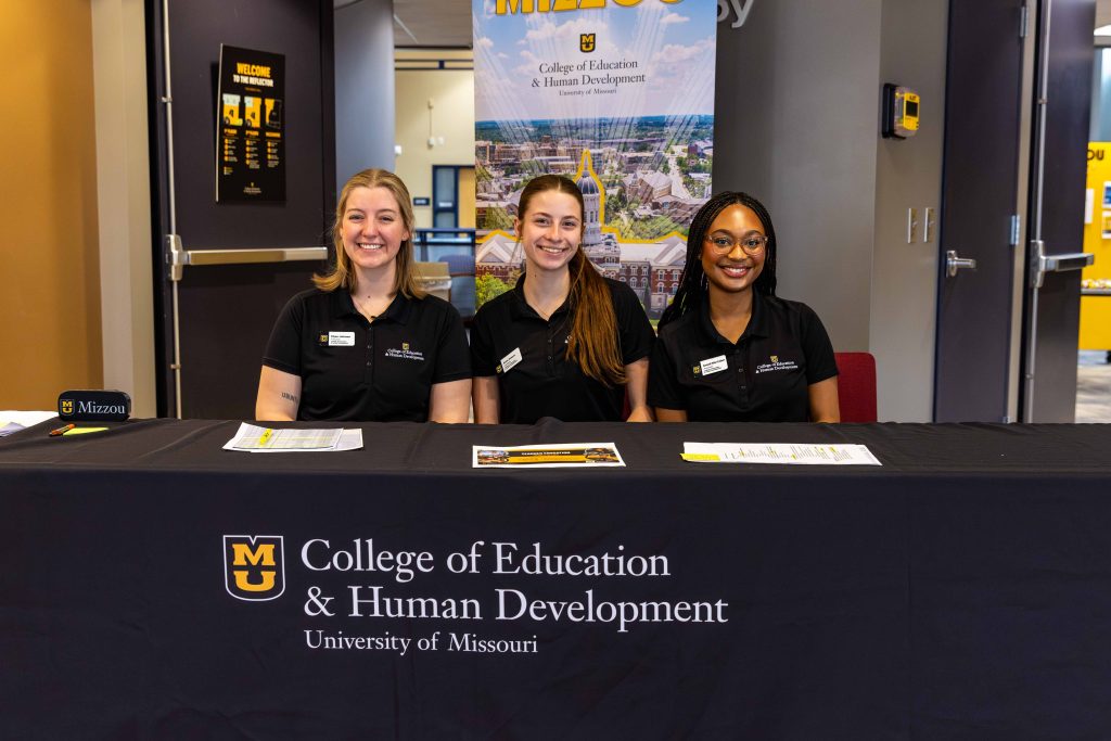 three people smiling for a camera