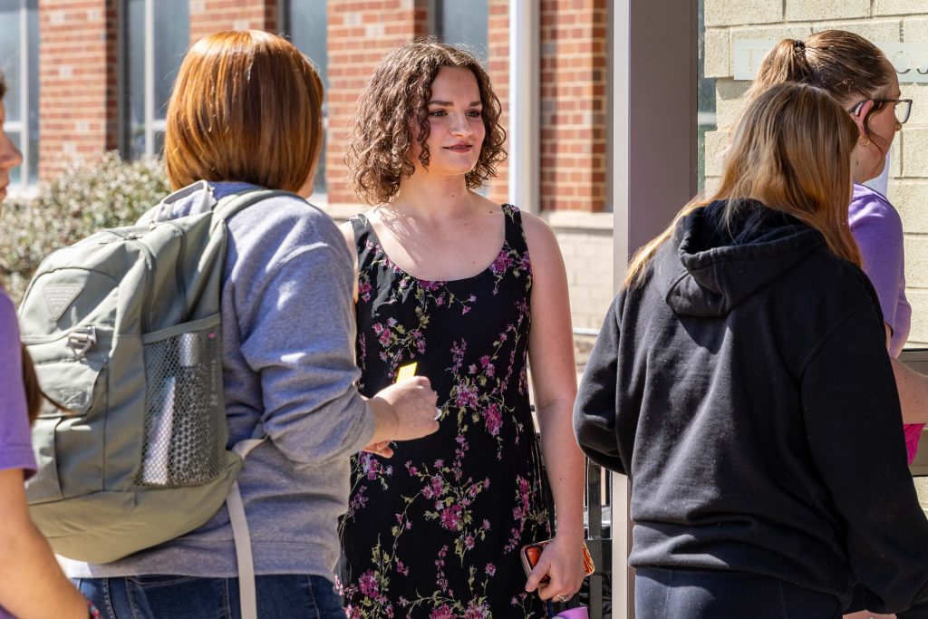 a person smiling in a crowd of students