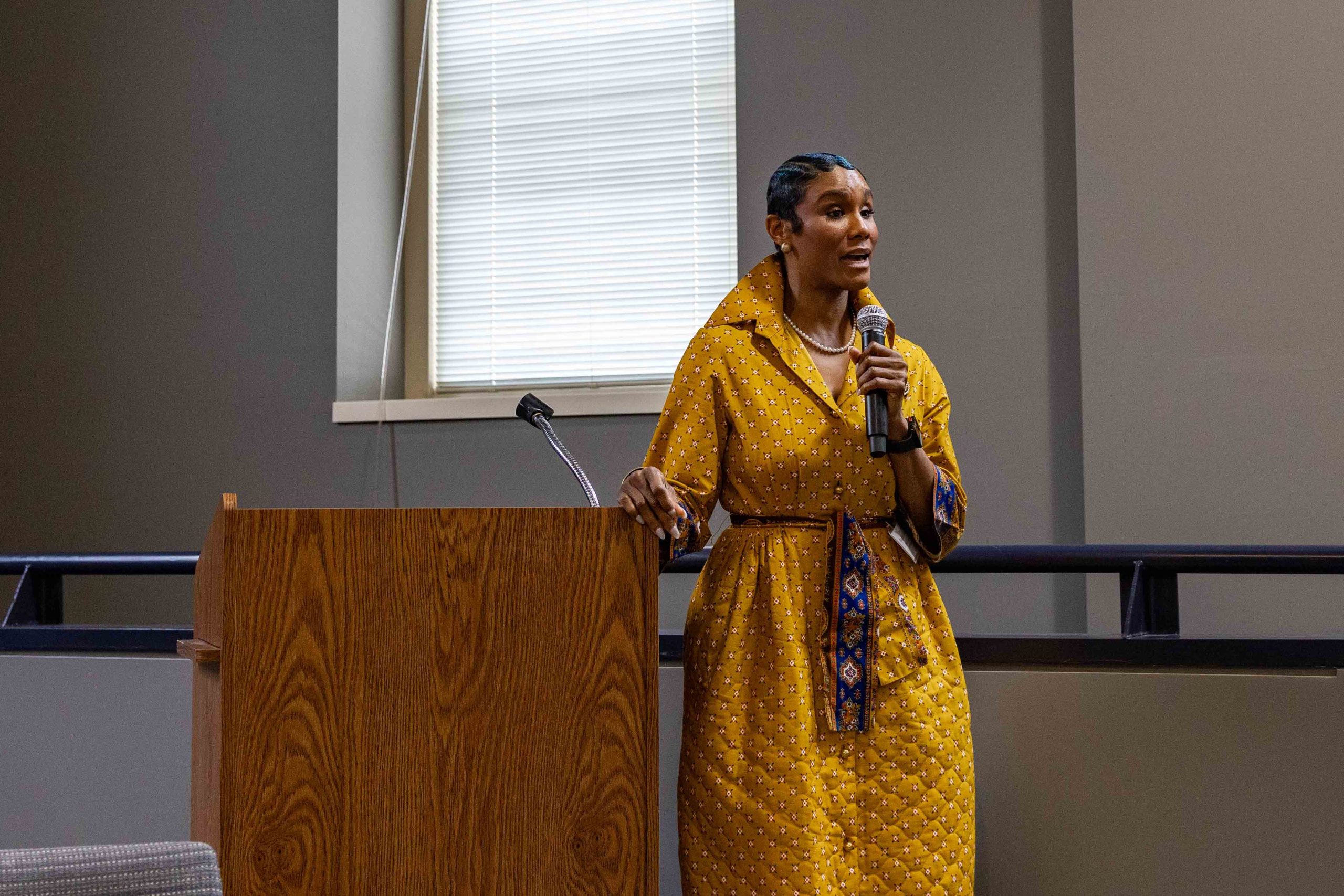 Raychel Proudie speaking at a microphone