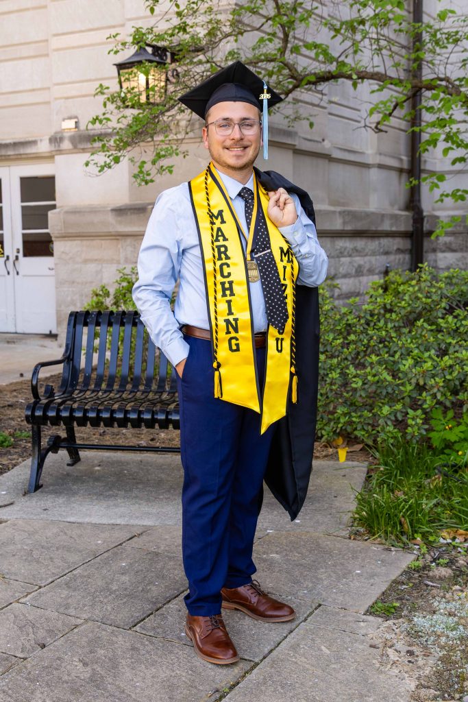 Thomas Skiendziel posing with a graduation gown