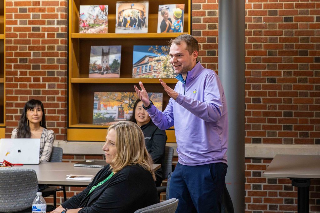 Faculty member speaking at a table