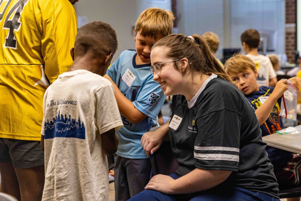 a smiling teacher looks at a student
