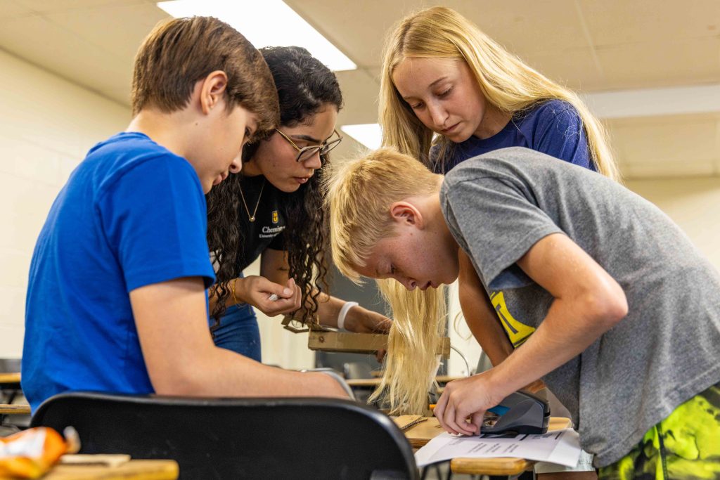 teacher and students working on something with high concentration
