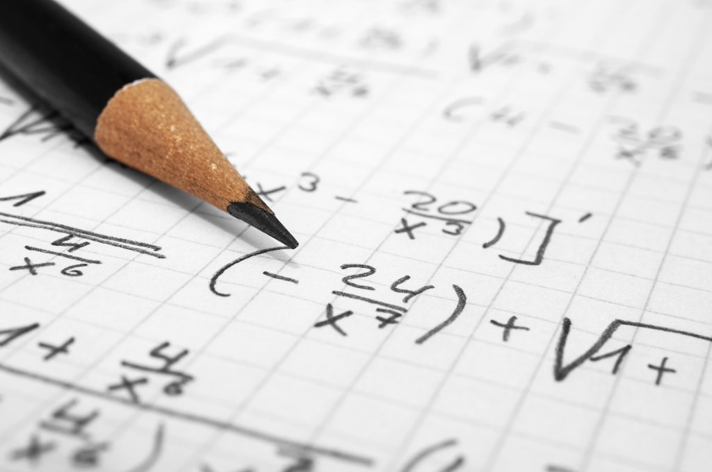 Maths concept - macro of a pencil over a sheet of paper with maths-formulas