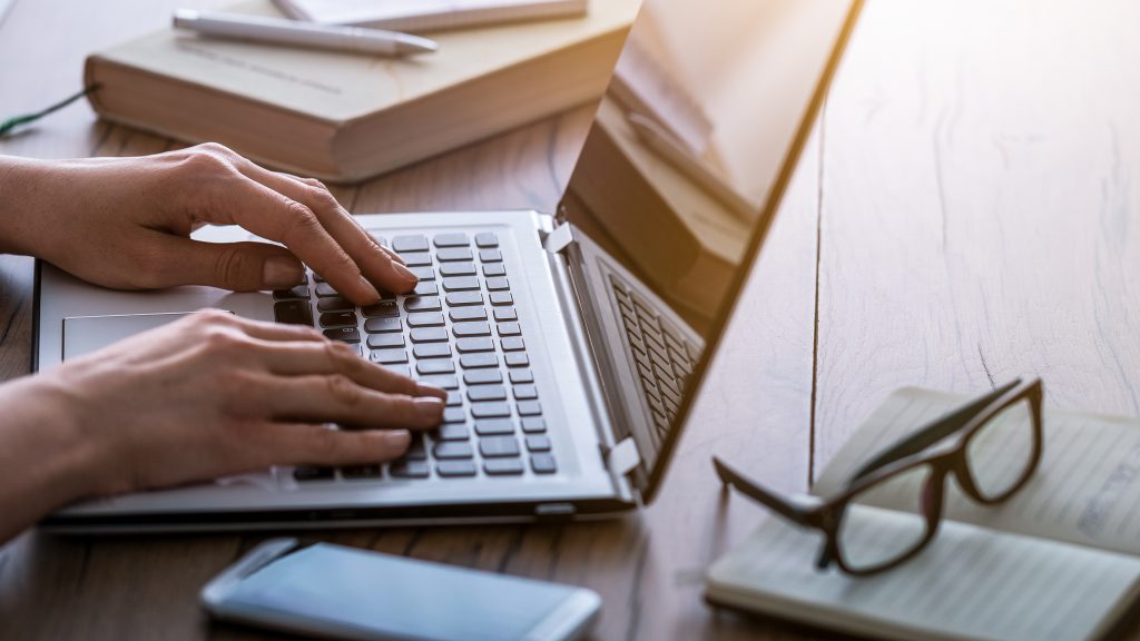 person writing on a laptop