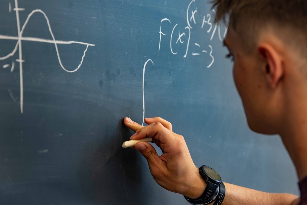 person writing on a chalkboard