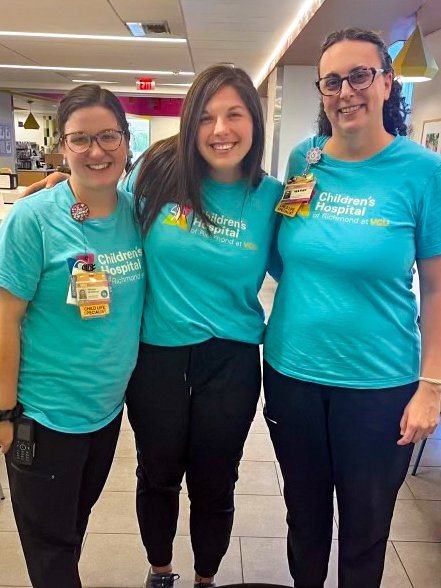Three child life associates smiling for the camera