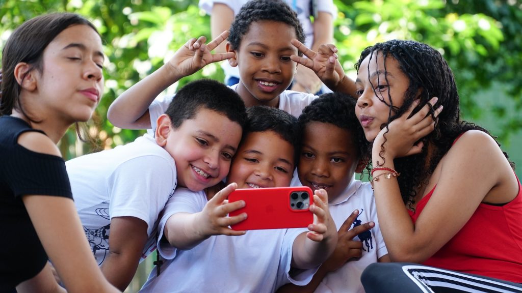 Children using a phone to take pictures.