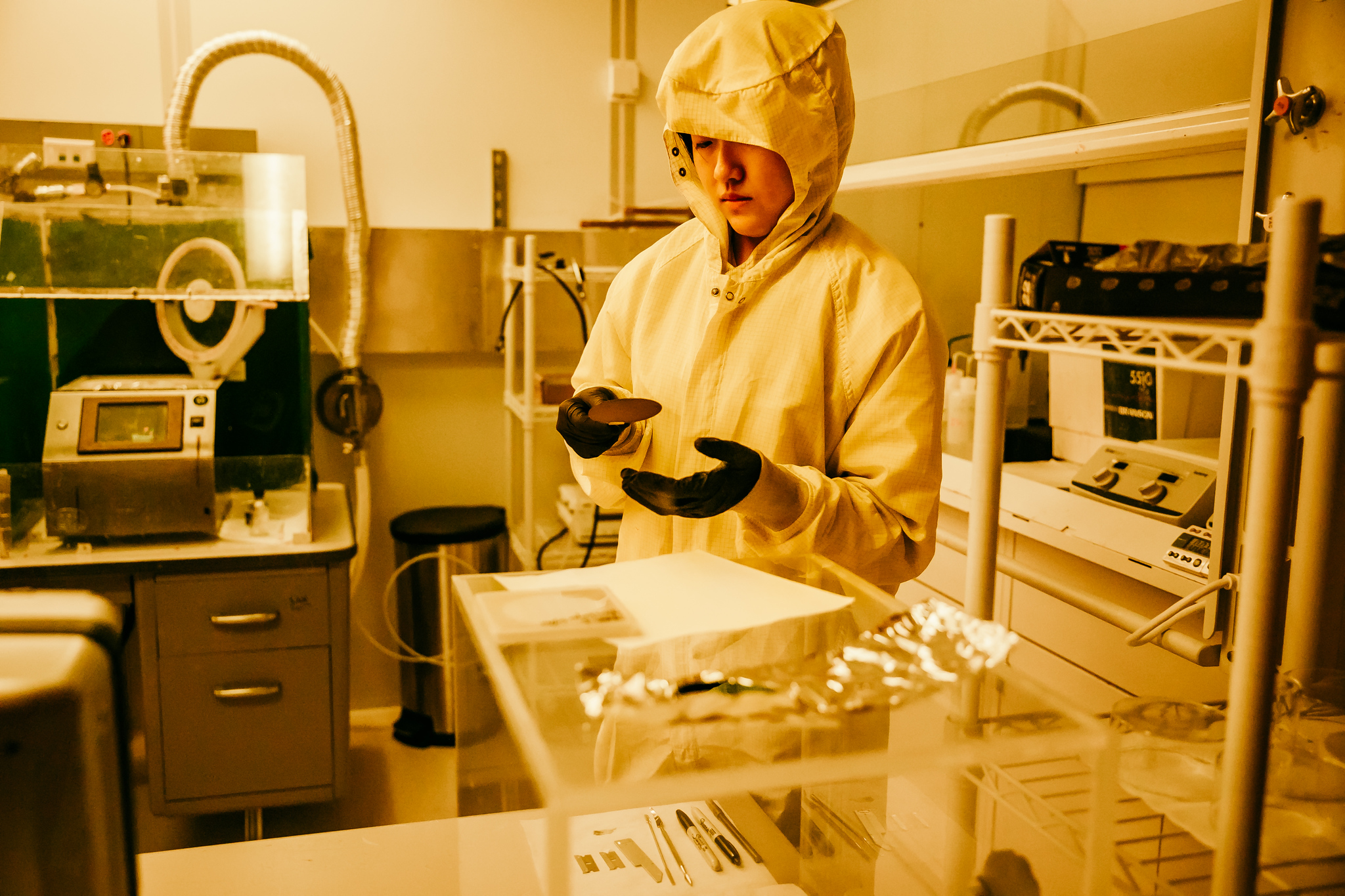 A clean room and a person holding a wafer
